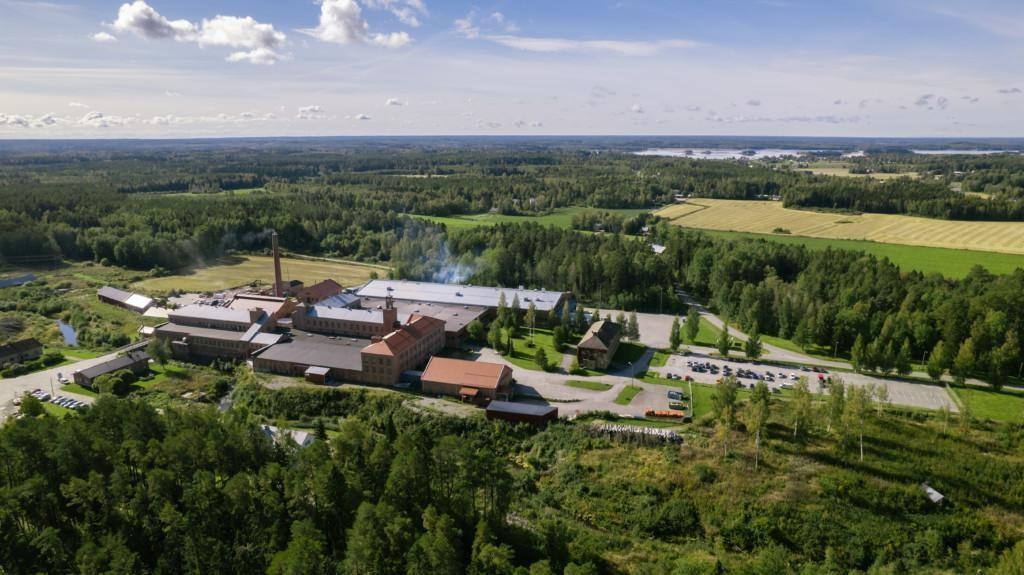 Factory area of Mirka Oravais, surrounded by green trees, photographed from above during summer time.